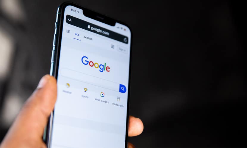 一个男人拿着他的iphone，上面有谷歌搜索引擎来突出点击付费和搜索引擎优化