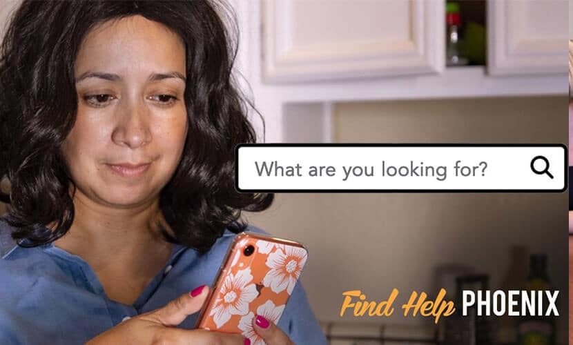 A woman looks at her phone thinking of what she is going to look for. Tag reads find help Phoenix.