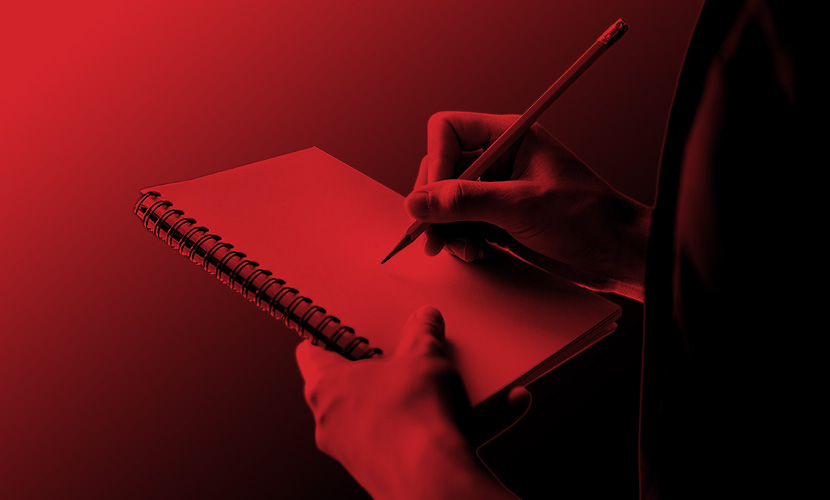 Close-Up Of Hand Writing In Notebook